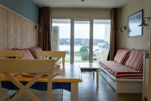 a living room with a couch and a table at Ti Cap - plage à pieds - Piscine in Crozon