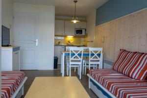 a living room with a couch and a table and a kitchen at Ti Cap - plage à pieds - Piscine in Crozon
