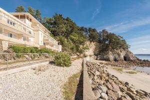 a building on the beach next to the ocean at Ti Cap - plage à pieds - Piscine in Crozon