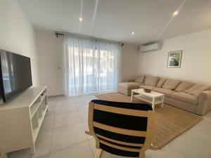 a living room with a couch and a television at Swieqi Malaika New Apt 2 with COURTYARD in Is-Swieqi