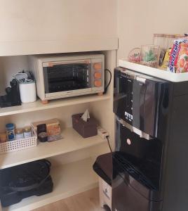 a kitchen with a microwave and a refrigerator at Damitsa Homestay Syariah in Wonosobo