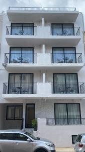 un edificio de apartamentos con balcones y un coche aparcado enfrente en Swieqi Malaika New Apt 2 with COURTYARD, en Is-Swieqi
