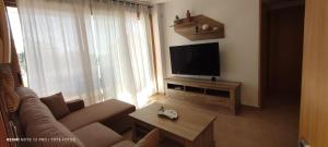 a living room with a couch and a television at Sierra Cortina Resort in Finestrat