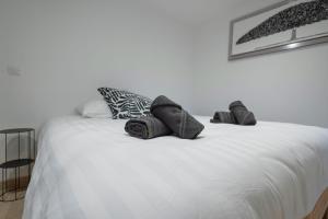 a white bed with two pillows on top of it at Le gîte du Haut de la Sousto in Rasteau