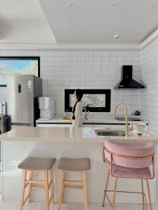 a woman standing in a kitchen with a counter at Okchae pension in Gyeongju +14 photos