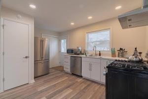 a kitchen with white cabinets and a black stove at Tin Roof Inn in Marion