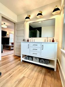 a bathroom with a white vanity and a large mirror at Tippecanoe Lakefront Classic Cottage in North Webster