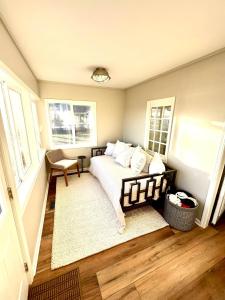 a bedroom with a bed in a room with windows at Tippecanoe Lakefront Classic Cottage in North Webster