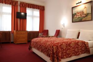 una camera d'albergo con un letto e una scrivania di Unitas Residence a Praga