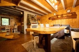 a kitchen and dining room with a table and chairs at Domek z kominkiem i jacuzzi in Łobozew