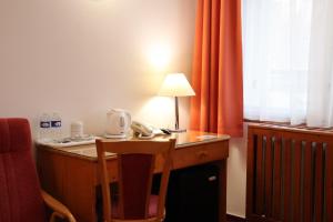 una scrivania con telefono e lampada di Unitas Residence a Praga