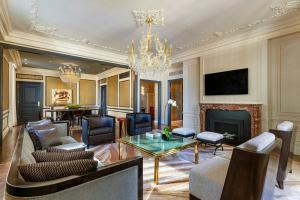 a living room with a chandelier and a fireplace at The St. Regis New York in New York