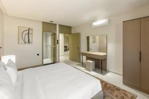 a bedroom with a white bed and a sink at Manazel Marez for serviced apartments in Al Madinah