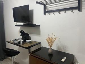 a room with a desk with a tv and a chair at Studio proche Tour Eiffel in Paris