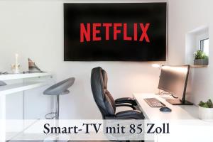 Un televizor și/sau centru de divertisment la Relax-Apartment Biberach - Relax Massagesessel - Smart-TV 85 Zoll - voll ausgestattete Küche - High-Speed Internet - Arbeitsplatz mit Curved Monitor