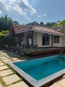 AnkolaにあるVilla Aayra - Premium cozy stay - 2BHK AC Villaの家の前にプールがある家