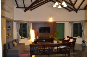 AnkolaにあるVilla Aayra - Premium cozy stay - 2BHK AC Villaのソファとテレビのあるリビングルーム