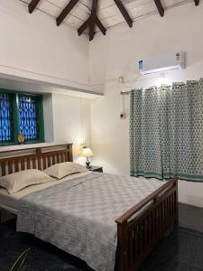 AnkolaにあるVilla Aayra - Premium cozy stay - 2BHK AC Villaの大きなベッドと2つの窓がある寝室