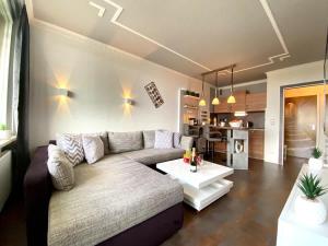 a living room with a couch and a table at RelaxApartments ABENDSONNE im Herzen des Harzes - ein El Dorado für Wanderer, Biker und Ruhesuchende - mit sonnigem Balkon und Platz für bis zu 3 Personen in Hahnenklee-Bockswiese