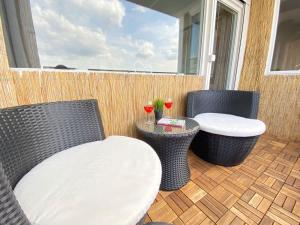 a patio with two chairs and a table and two wine glasses at RelaxApartments ABENDSONNE im Herzen des Harzes - ein El Dorado für Wanderer, Biker und Ruhesuchende - mit sonnigem Balkon und Platz für bis zu 3 Personen in Hahnenklee-Bockswiese