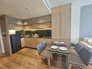 a living room with a table and chairs and a kitchen at Modern apartment Layan Beach in Layan Beach +3 photos