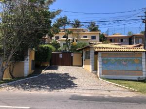a house with a gate and a driveway at Casa 6 Mares de Búzios - 5 minutos a pé da Rua das Pedras in Búzios