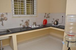 a kitchen with a sink and a counter top at Amutham Inn in Chennai