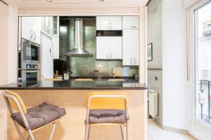 een keuken met 2 stoelen en een aanrecht bij Exclusivo apartamento en el centro by beBalmy in Madrid
