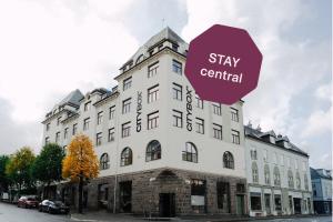 Ein großes weißes Gebäude mit einem Schild, auf dem „Stay central“ steht. in der Unterkunft Citybox Bergen City in Bergen