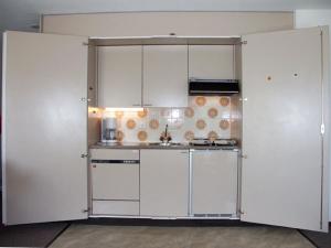 una cocina blanca con armarios y electrodomésticos blancos en Davos Swiss Alps, en Davos