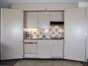 a white kitchen with white cabinets and appliances at Davos Swiss Alps in Davos