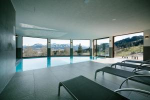a house with a swimming pool with a view of mountains at Panoramahotel Kühbergalp in Gunzesried