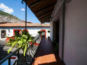 a balcony of a building with a fence and plants at Hotel Casa Domínguez in Taxco de Alarcón