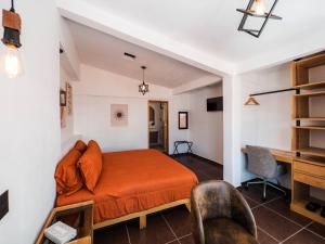 a bedroom with a bed and a desk at Hotel Casa Domínguez in Taxco de Alarcón
