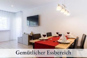 a dining room with a table with a red table cloth at Ferienwohnung EDEN Apartment´s Vinum in Friedrichshafen