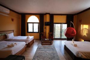 a hotel room with two beds and a window at Nubiano Cataract in Shellal