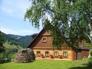 ein großes Holzhaus mit einem Dach in der Unterkunft Bouda Na Cestě in Pec pod Sněžkou