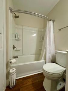 a bathroom with a toilet and a tub and a shower at Campus Den On Poplar St in Marion