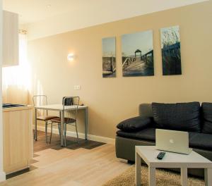 ein Wohnzimmer mit einem Sofa und einem Tisch mit einem Laptop in der Unterkunft Boardinghotel Heidelberg in Heidelberg