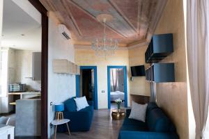 a living room with a blue couch and a chandelier at La Venere Suite in Fezzano