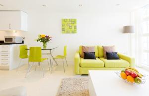 a living room with a yellow couch and a table at 28 Rocklands in Newquay in Newquay