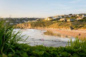 a beach with a group of people in the water at 28 Rocklands in Newquay in Newquay
