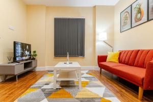 a living room with a red couch and a tv at Cozy Modern 1 Bed Flat Walsall Town Centre in Walsall