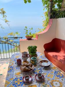 a table with plates of food on top of a balcony at Positano's Flats in Positano