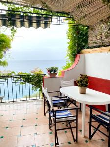 a patio with a table and chairs and a view of the ocean at Positano's Flats in Positano
