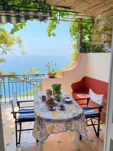 a table and chairs on a patio with a view of the ocean at Positano's Flats in Positano