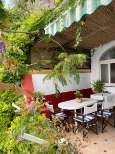 a patio with a table and chairs and plants at Positano's Flats in Positano