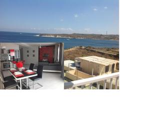 Penthouse next to the beach في مارساسكالا: مطبخ وغرفة معيشة مطلة على المحيط