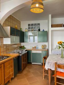 a kitchen with green cabinets and a table with a tableablish at Positano's Flats in Positano