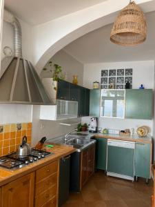 a kitchen with green cabinets and a sink at Positano's Flats in Positano
